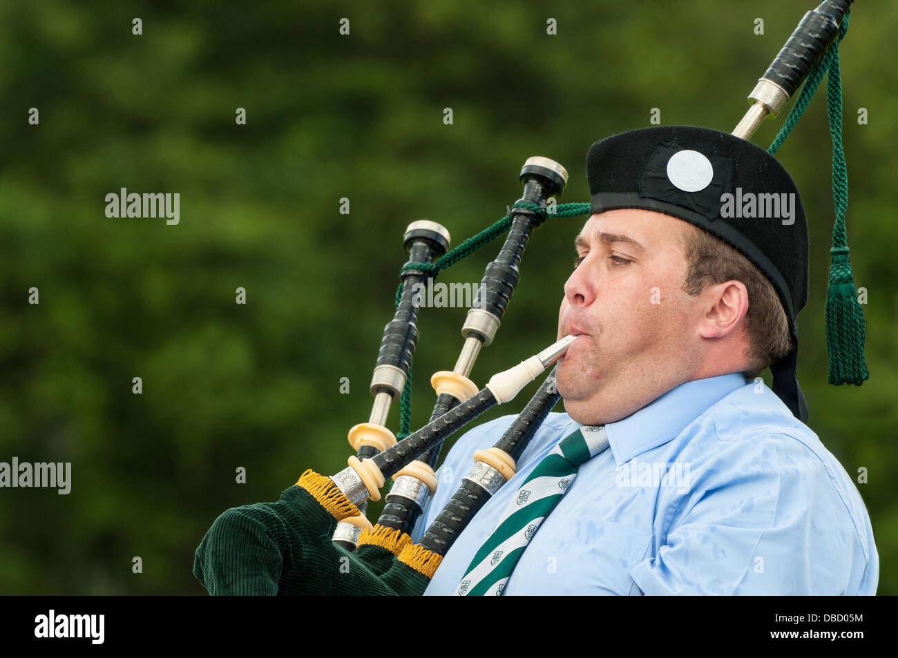Eine schottische Piper ignoriert den Regen um ein eindringliches Klagelied auf seinem Dudelsack zu spielen. Stockfoto