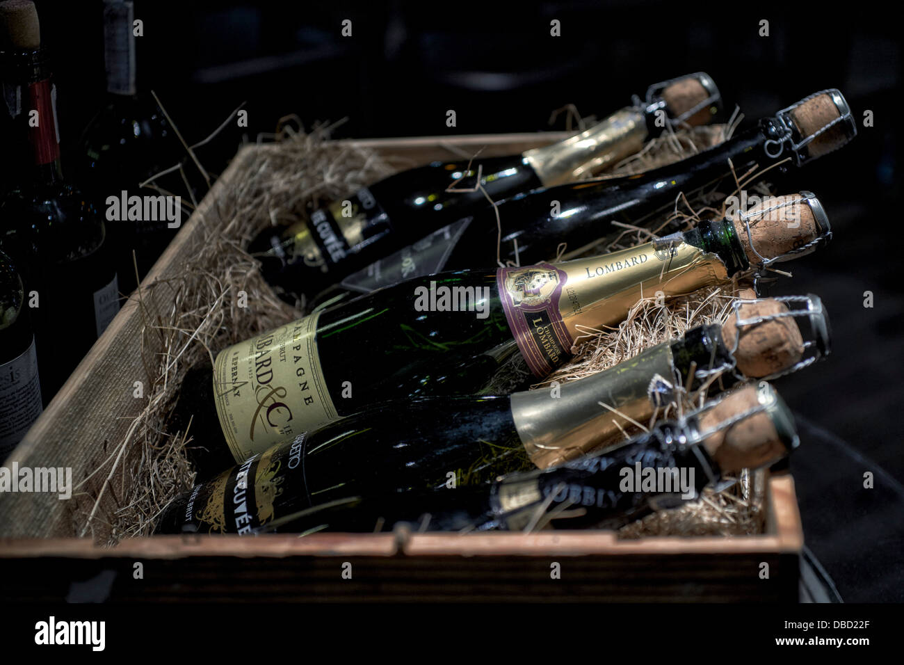 Champagne-Flaschen in einen Strohhalm ausgekleidet Holzkiste Stockfoto