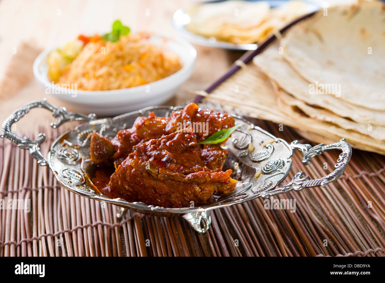 Butter Chickencurry mit Basmati-Reis und verschiedenen indischen Speisen im Hintergrund Stockfoto