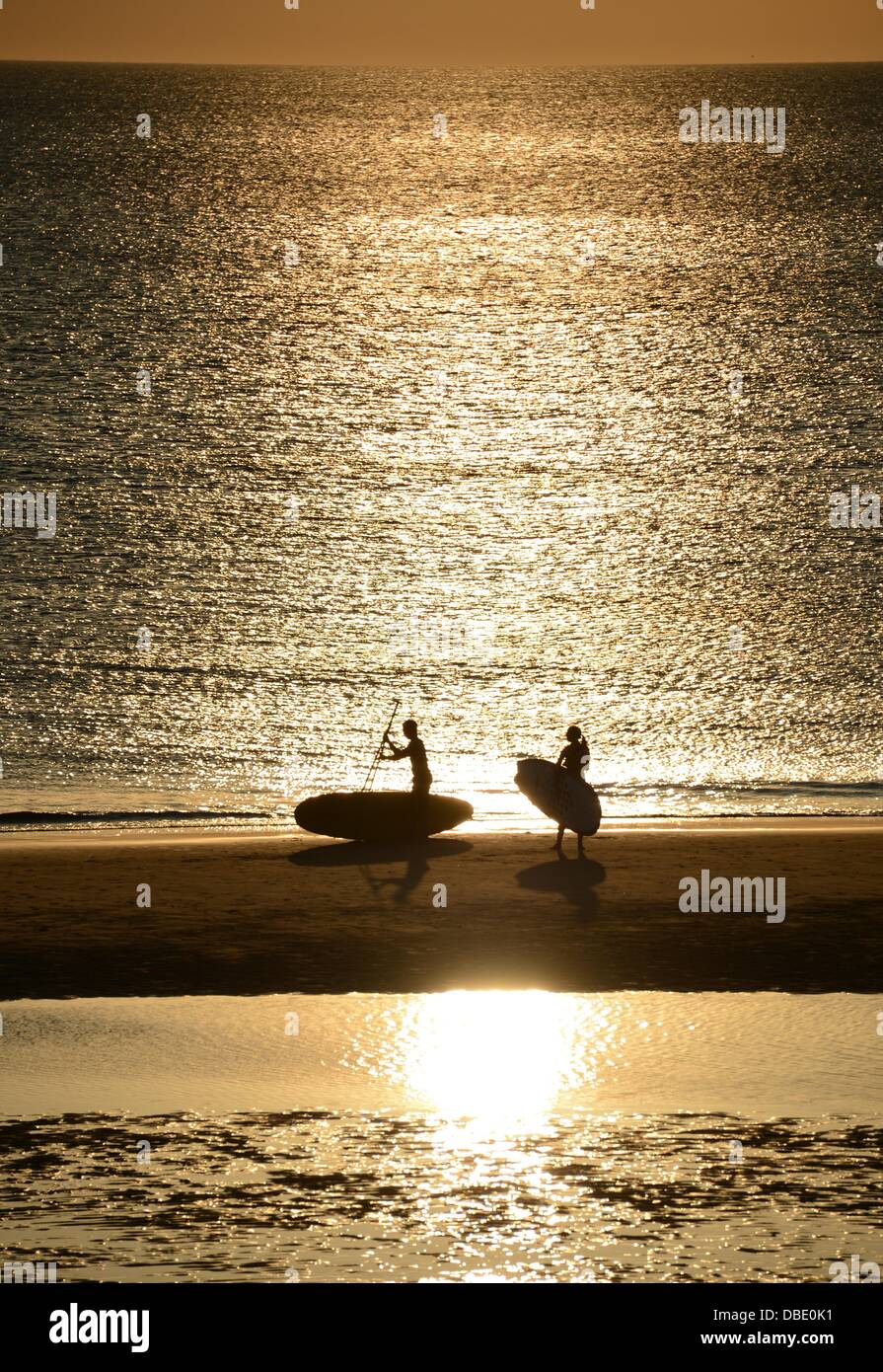 Surfer aus dem Wasser zu bekommen und Fuß entlang des Strandes im Licht der untergehenden Sonne am Strand von Westerland auf Sylt, Deutschland, 23. Juli 2013. Foto: Jens Kalaene Stockfoto
