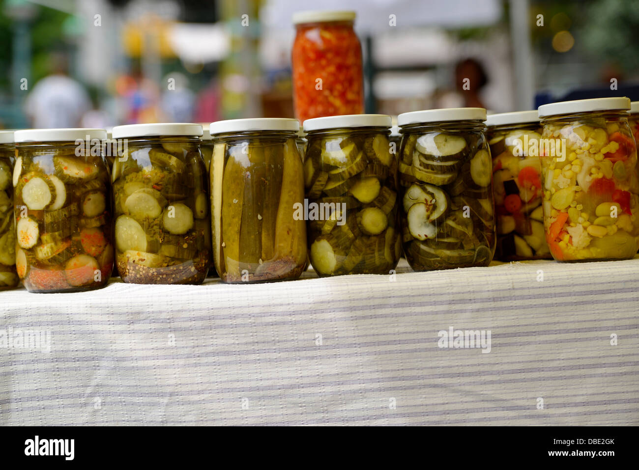 Gläser mit Gurken und Mais Relish, dargestellt auf einem Tisch, auf einem Outdoor-Bauernmarkt Stockfoto