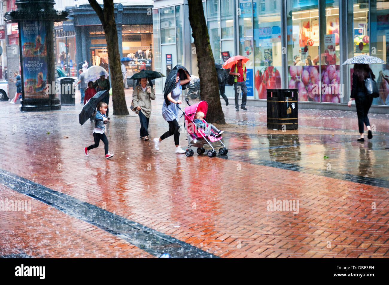 Birmingham, Vereinigtes Königreich. 29. Juli 2013. Shopper für Abdeckung als eine plötzliche Starkregen laufen Sturm Kaskaden hinunter auf das Stadtzentrum, Birmingham, UK, Montag, 29. Juli 2013. Bildnachweis: John Bentley/Alamy Live-Nachrichten Stockfoto