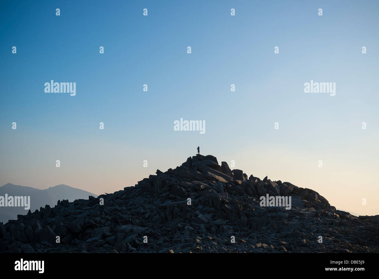 Silhouette der einsame Wanderer auf felsigen Gipfelaufbau des Glyder Fach, Snowdonia-Nationalpark, Wales Stockfoto
