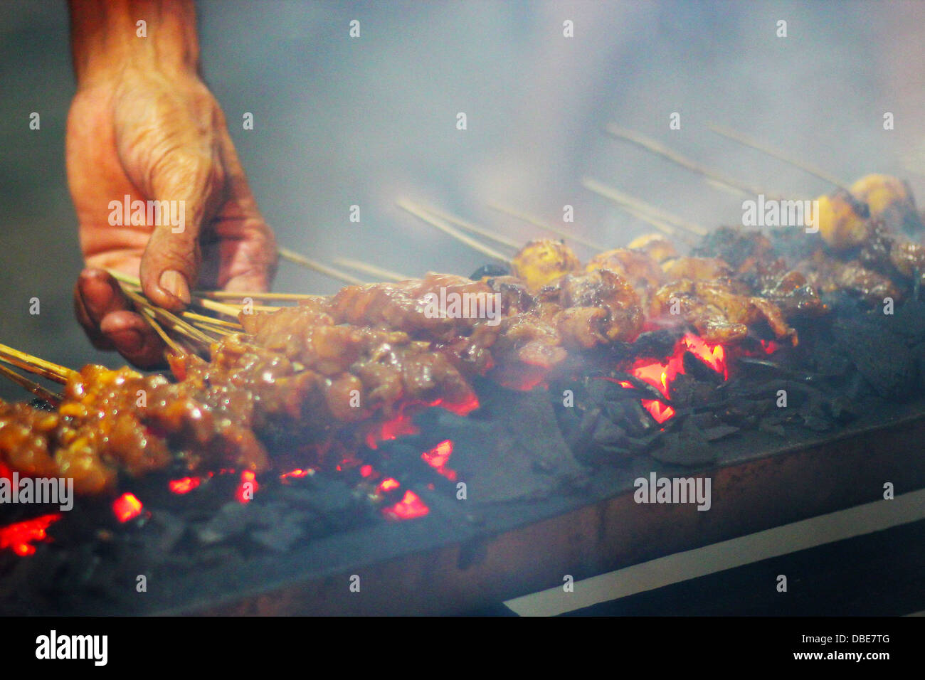 Ein Markt-Verkäufer grillen Fleisch Satay auf Köhler auf den Straßen von Jakarta, Indonesien. Stockfoto
