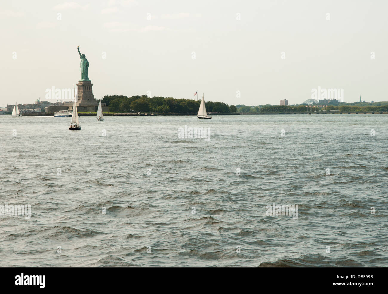 Ein Blick auf den Hafen von New York mit der Statue of Liberty und Segelboote. Stockfoto