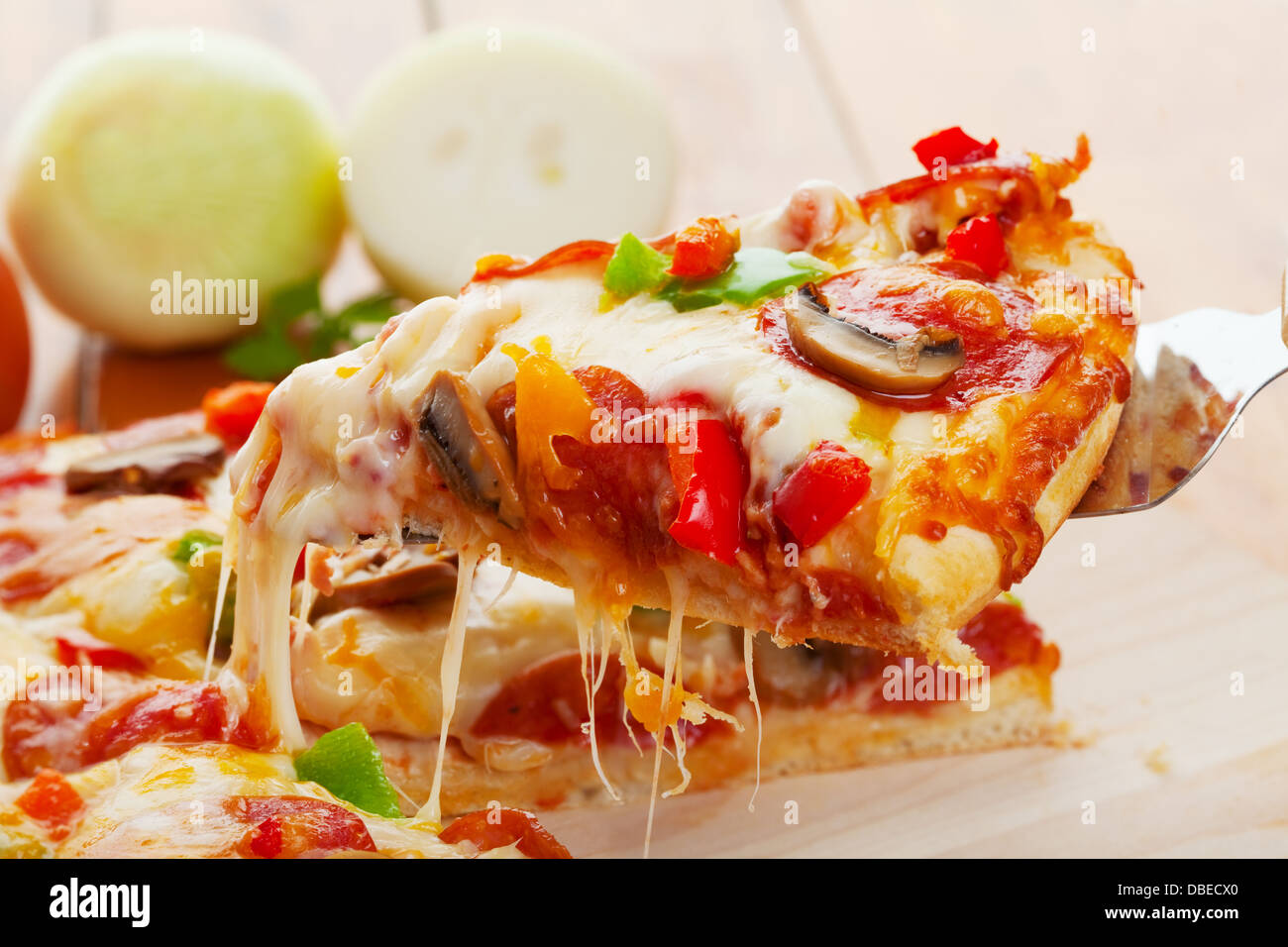 Ein Stück oberste Pizza wird angehoben Stockfoto
