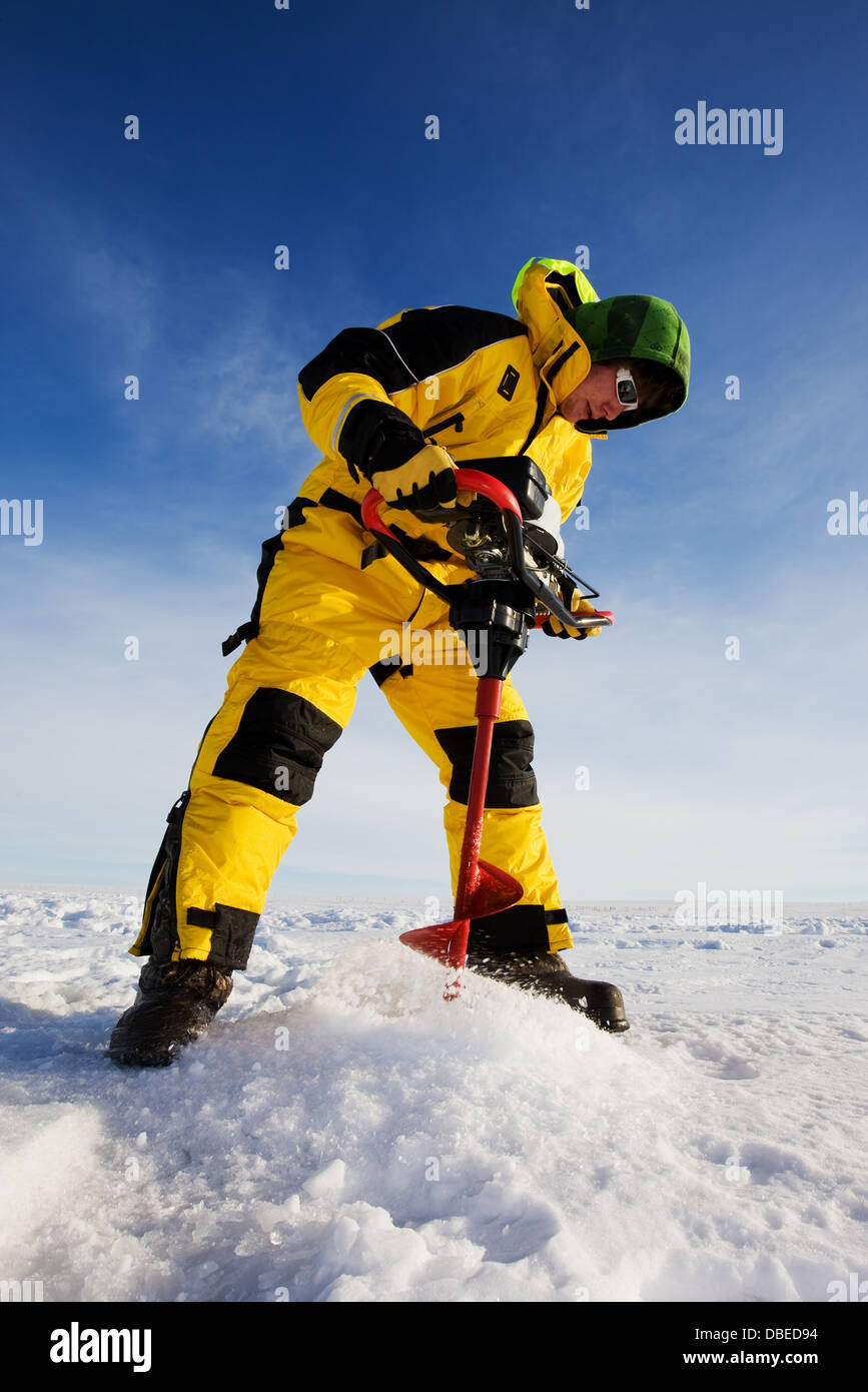 Bohren eine Loch auf einem zugefrorenen See mit einer Schnecke macht Eis-Fischer Stockfoto