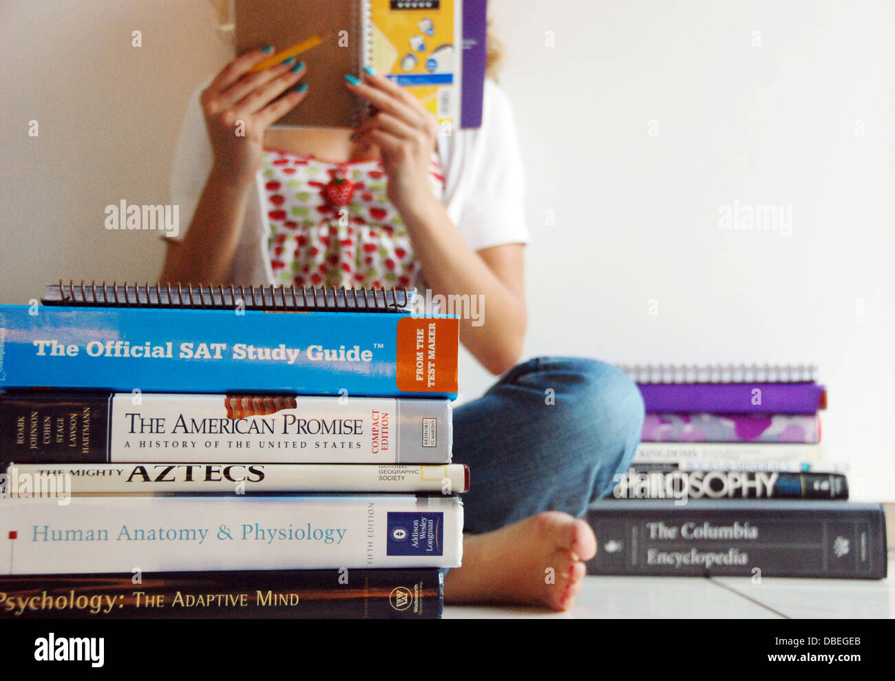 Ein Student Studien für SAT Test-Prüfungen für die Schule in einem Stapel Bücher und Lehrbücher Stockfoto