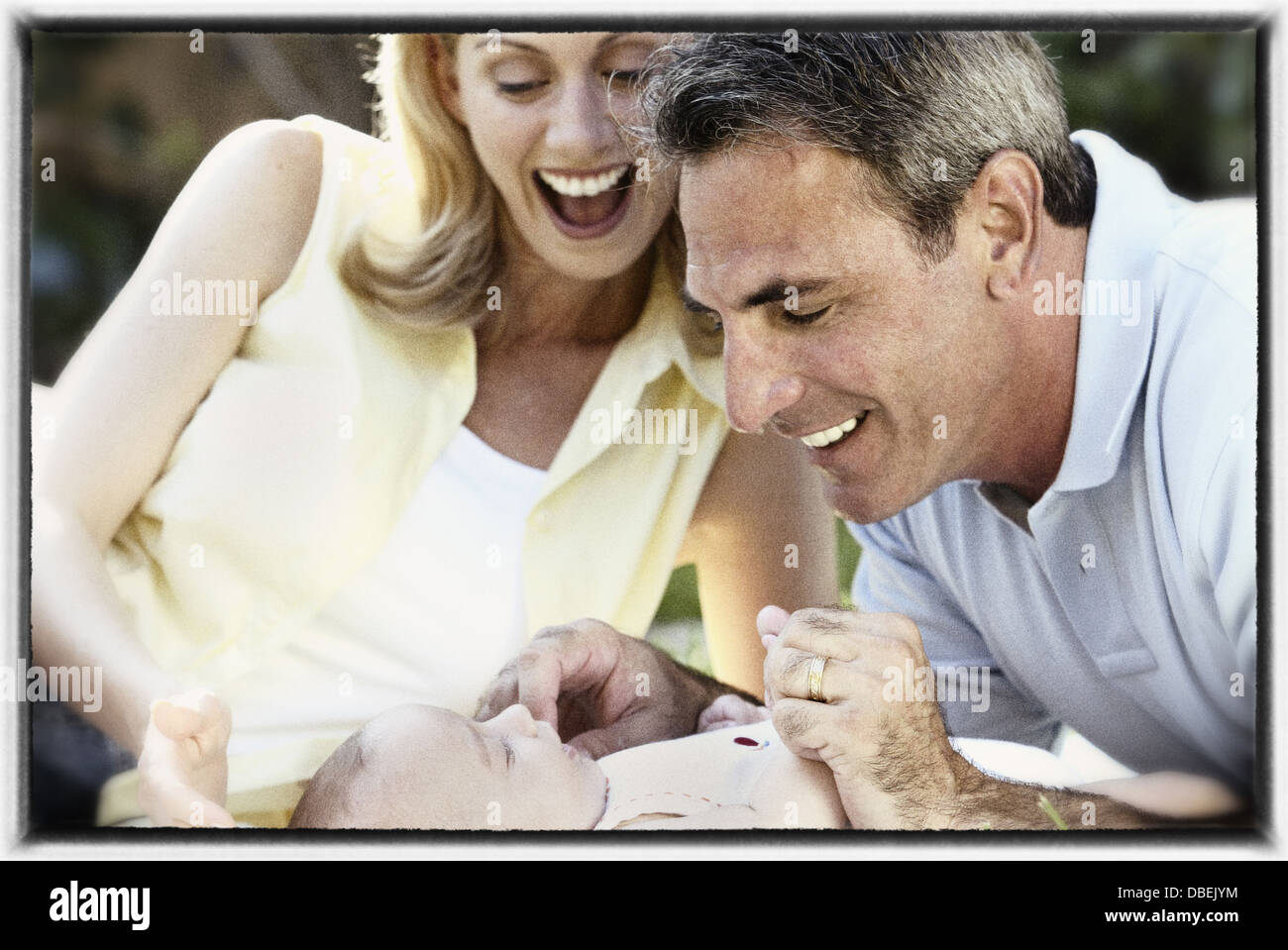 Hispanische Mutter und Vater mit Baby spielen - Smartphone-aufgenommenes Stockfoto