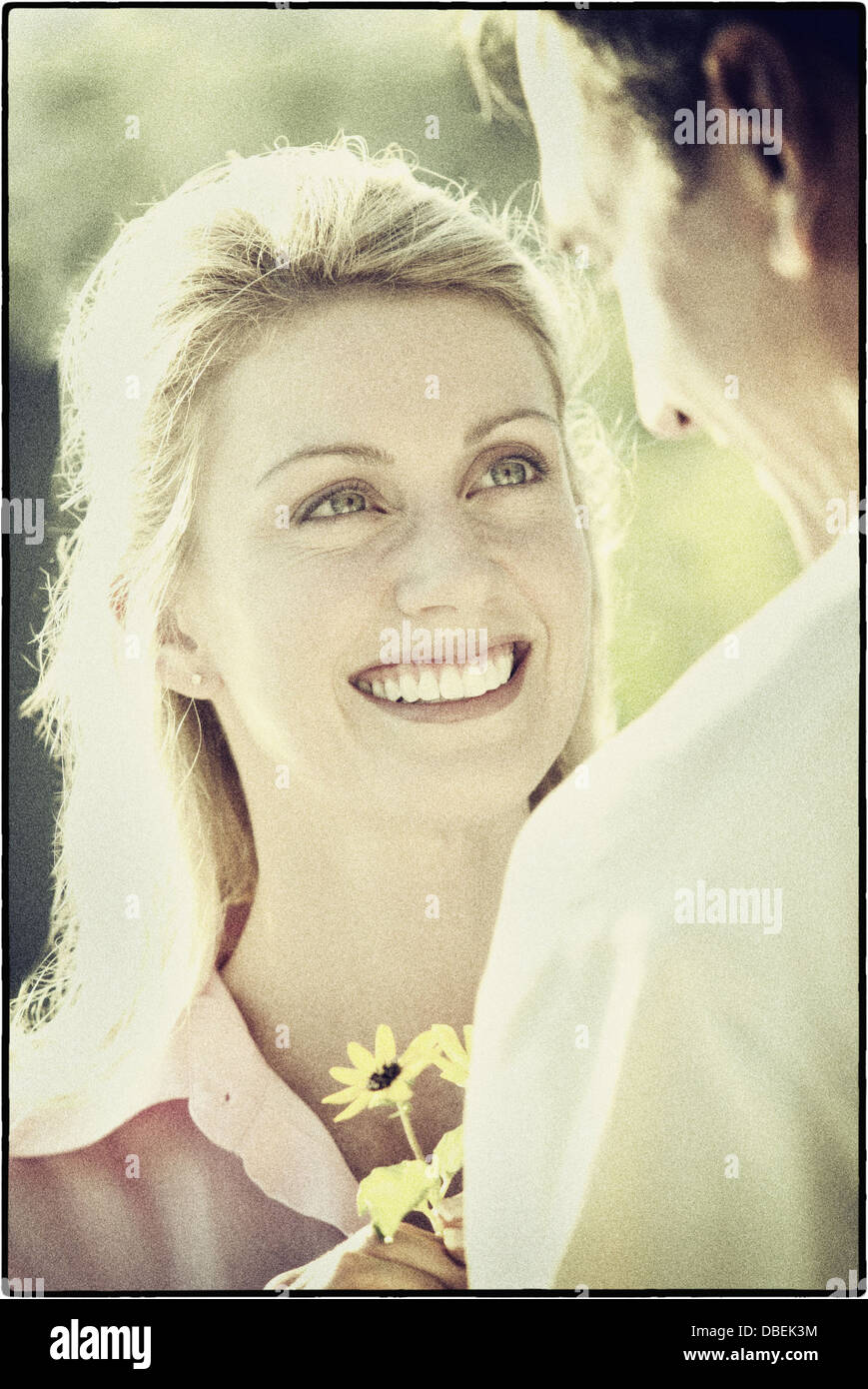 Hispanic Mann Freundin Blumen schenken - Smartphone-aufgenommenes Stockfoto