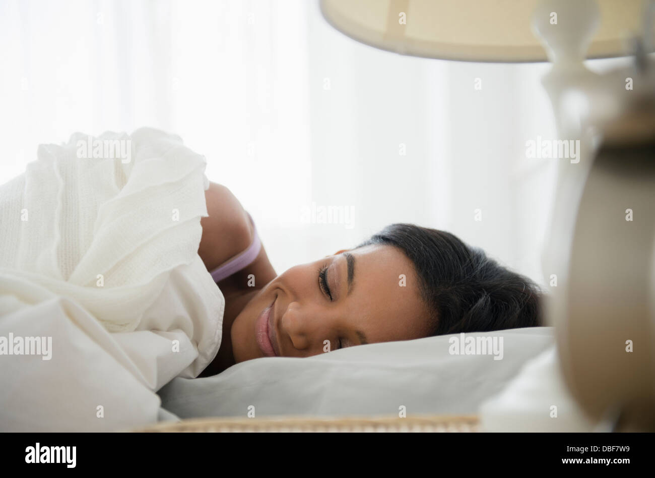 Mischrasse Frau schläft im Bett Stockfoto