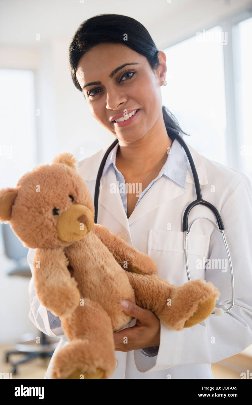 Indischer Arzt Teddybär im Amt halten Stockfoto