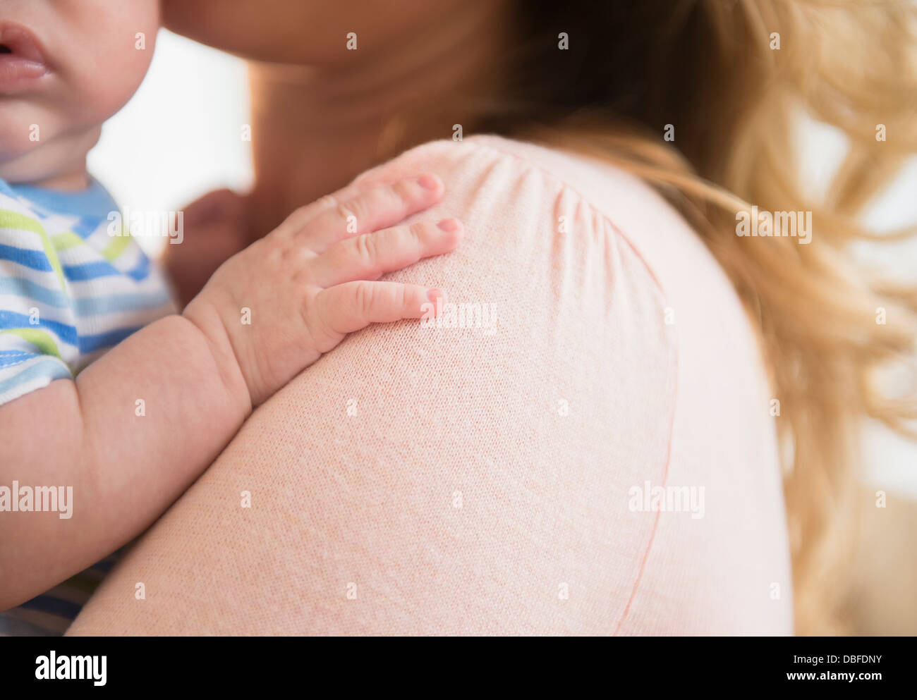 Kaukasischen Babys Hand auf Mutters Schulter Stockfoto