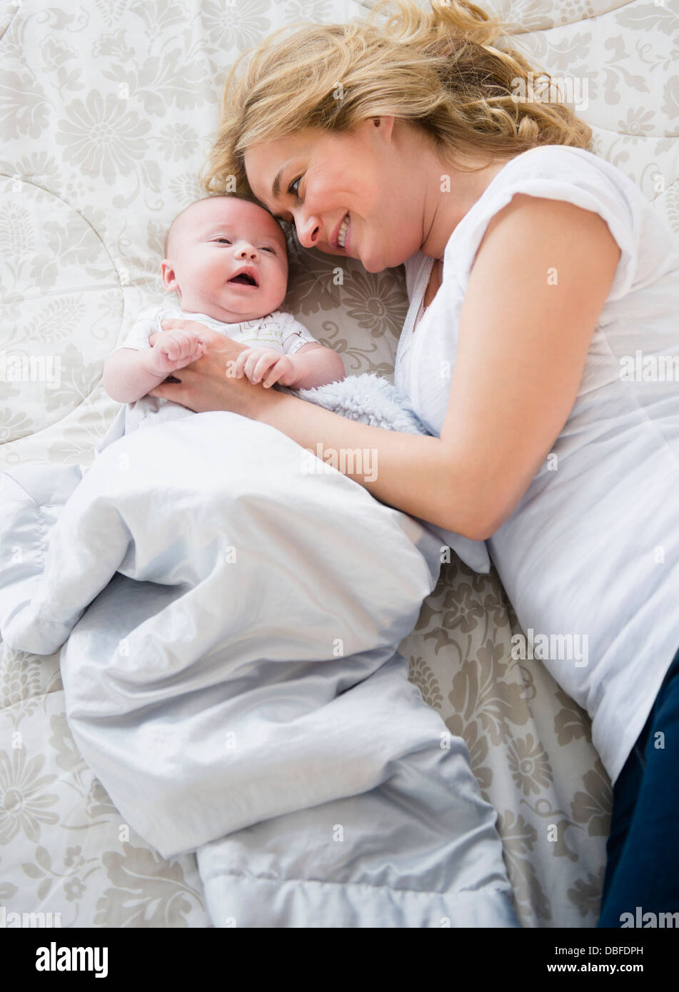 Kaukasische Mutter und Baby auf Bett Stockfoto