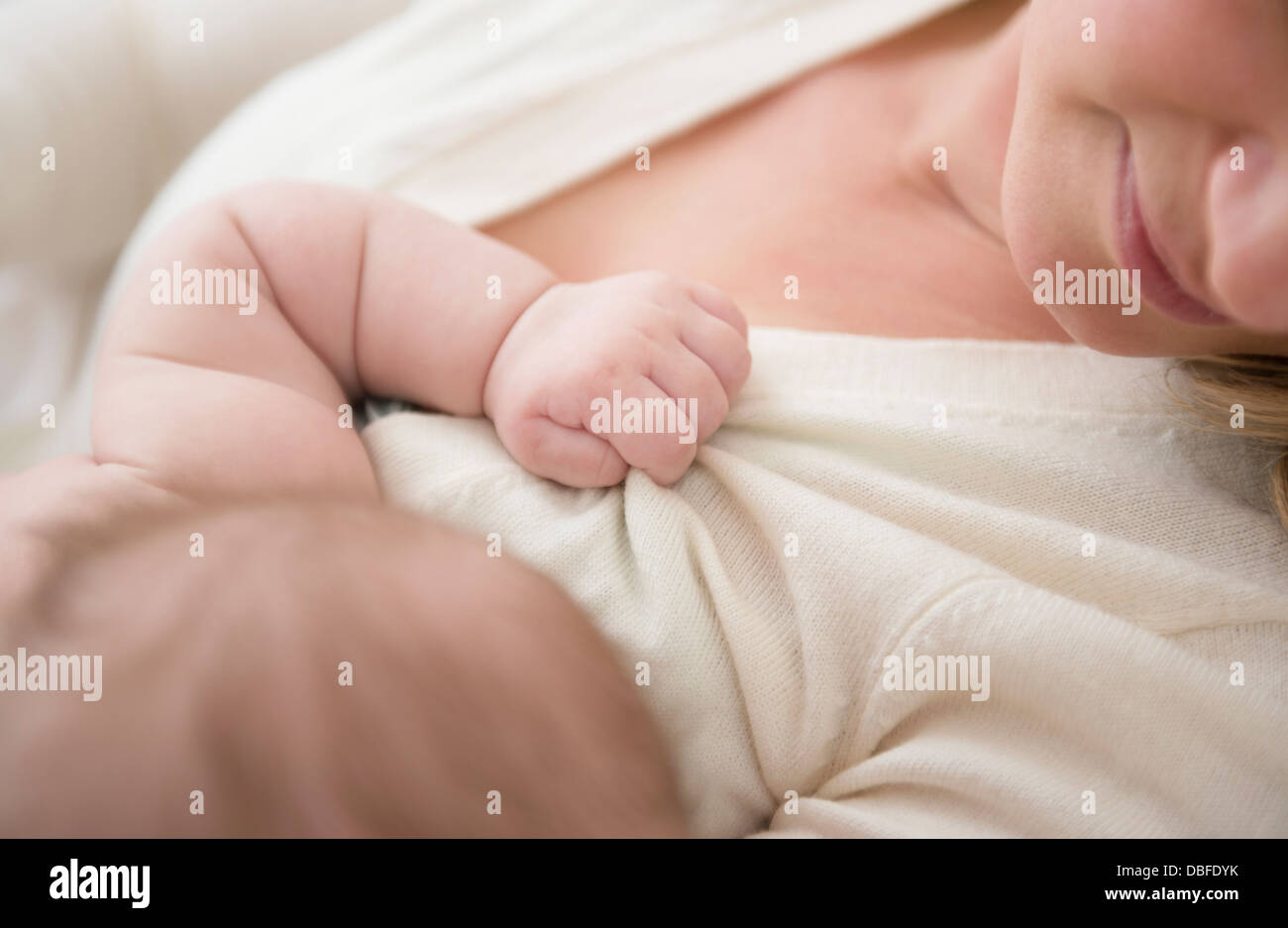 Kaukasische Baby greifen Mutter Pullover Stockfoto