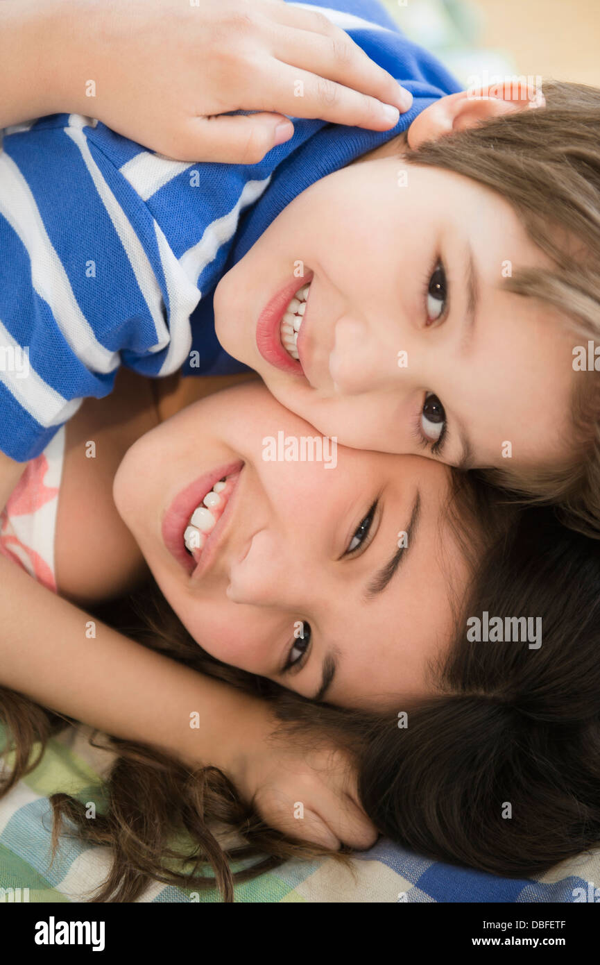 Hispanischen Kinder umarmt auf Bett Stockfoto