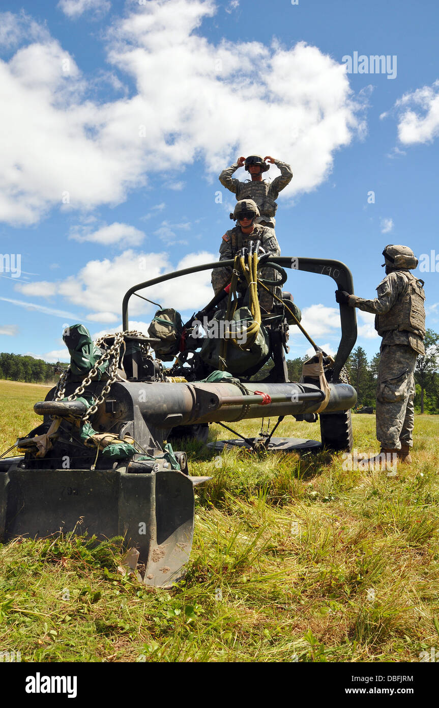 Kanone-Crew-Mitglieder aus dem 1. Bataillon, 120. Feldartillerie erwarten die Ankunft eines Black Hawk-Hubschrauber aus dem 1. Bataillon, 147. Aviation Regiment, Sling-Last die 105-mm-Haubitze für den Transport als Teil einer kombinierten Waffen training Mission Juli Stockfoto