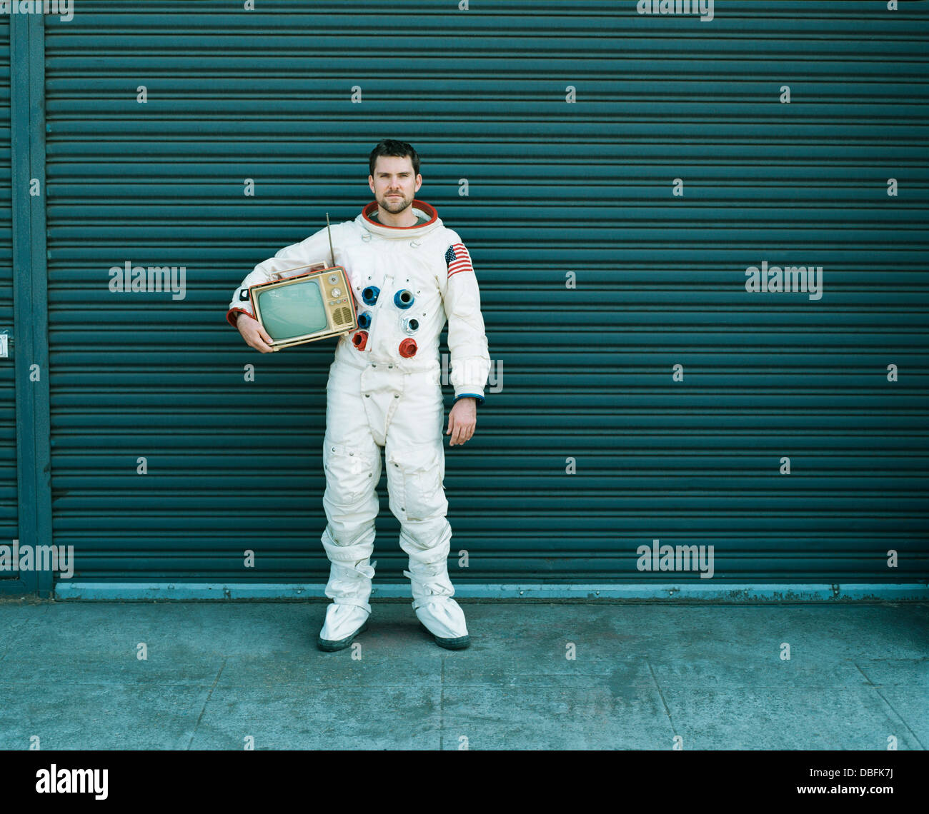 Astronauten tragen Fernsehen auf Stadtstraße Stockfoto