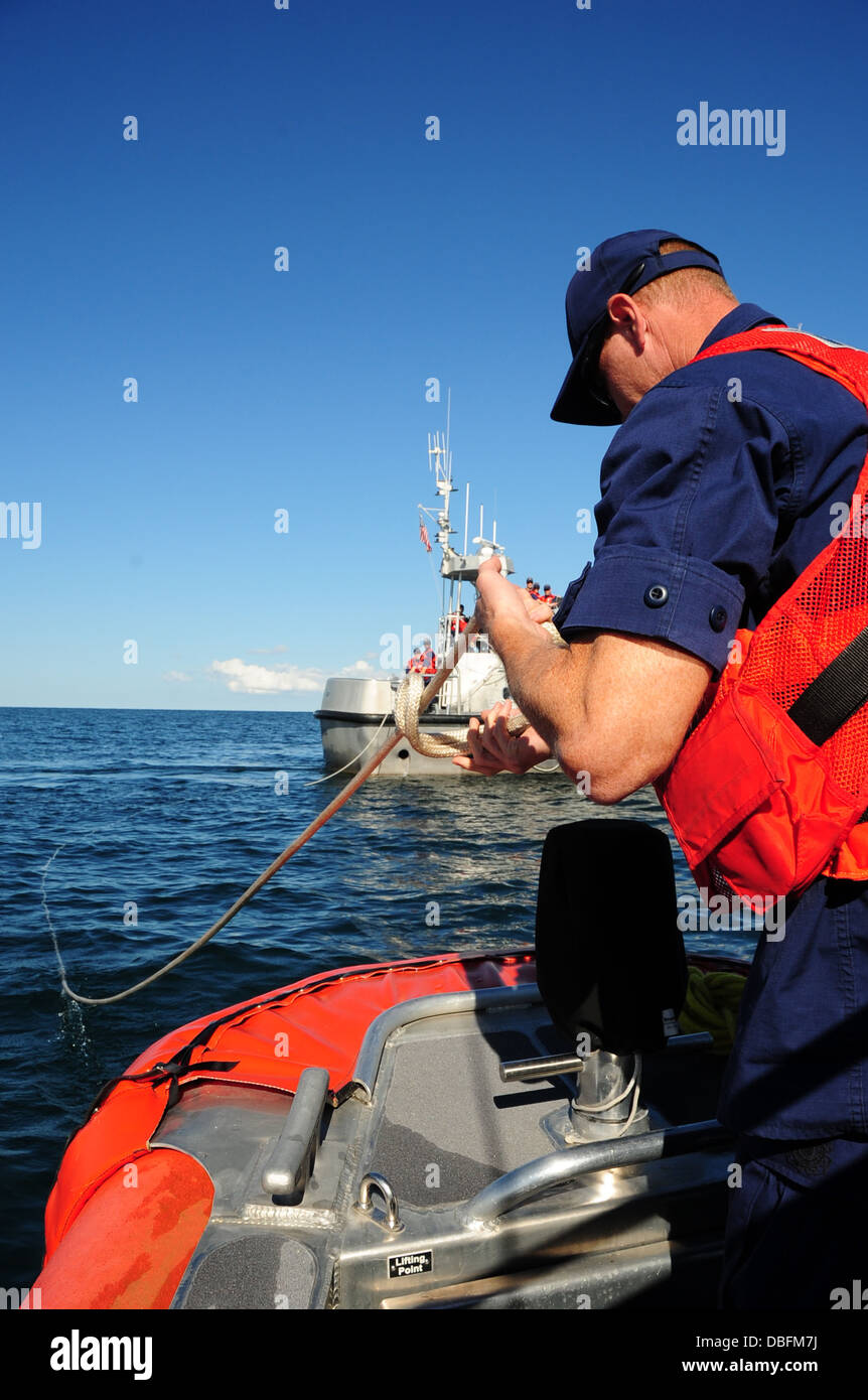 Petty Officer 1st Class Gregory Purdy, von der Coast Guard Station Oswego, New York, übernimmt eine Schleppleine nach dem Trennen der Linie von einem 25-Fuß Antwort Boot-klein, während einer Übung mit einer anderen Station Oswego Boatcrew an Bord ein 47-Fuß-Bewegungsleben Stockfoto