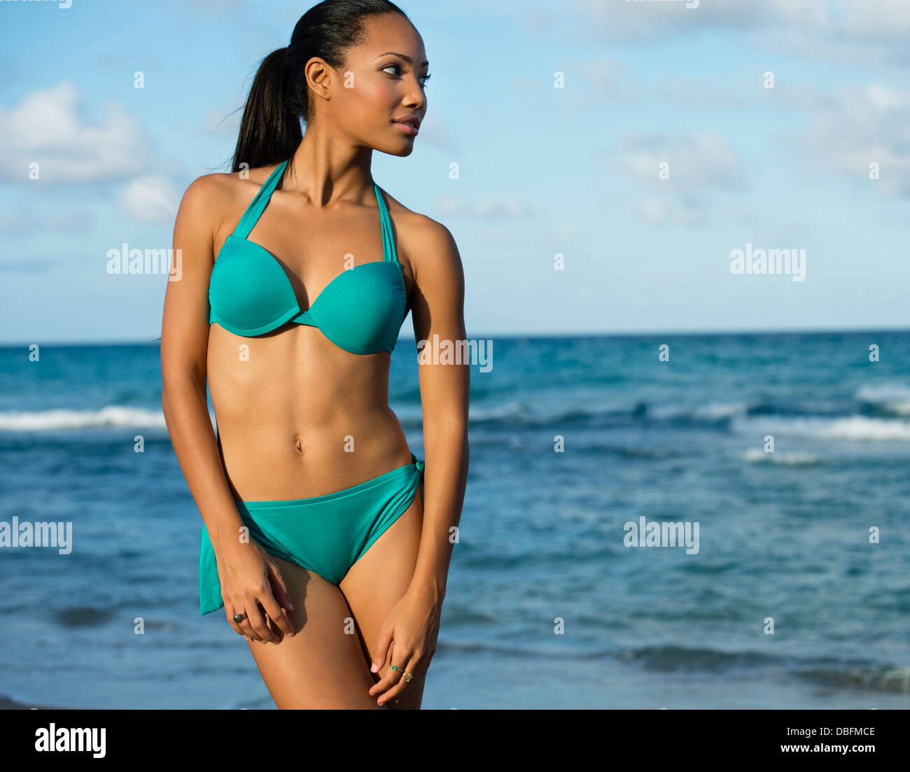 Hispanic Frau mit Bikini am Strand Stockfoto