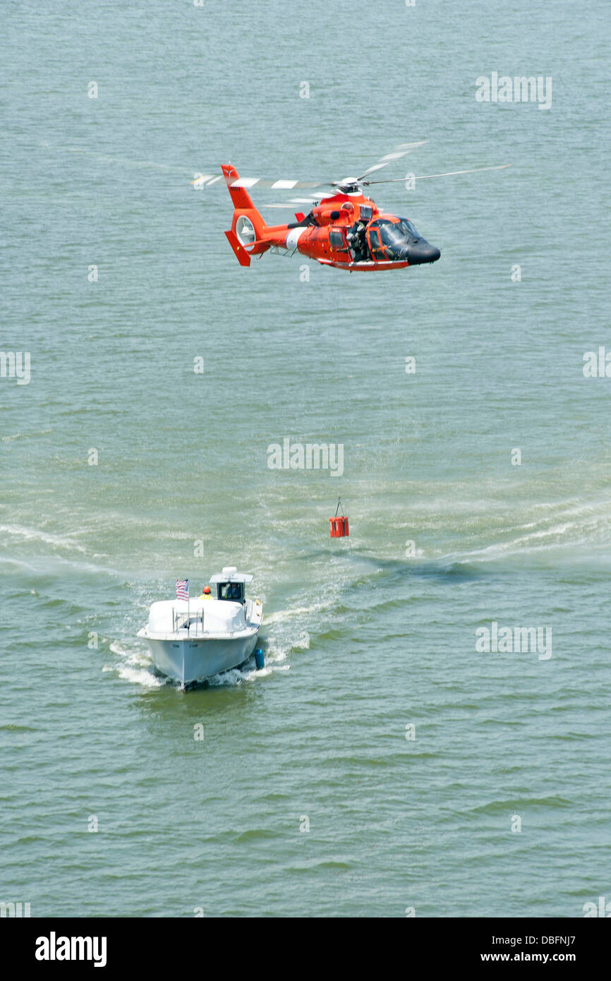 Coast Guard Air Station Houston Besatzungsmitglieder zu üben, Lieferung und hissen Techniken für eine Schöpfwerks während eines Trainings Fluges über Houston Ship Channel an Bord ein MH - 65D Dolphin-Helikopter 25. Juli 2013 Stockfoto