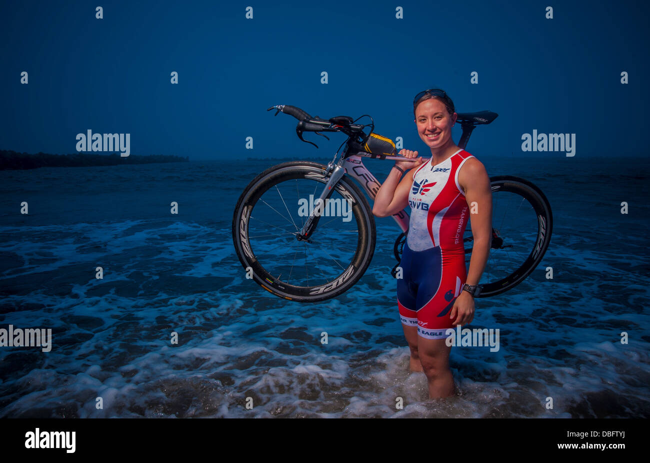 Capt Hila Levy, 35. Operations Support Squadron, posiert mit ihrem Triathlon-Rennrad im Pazifischen Ozean bei Miss Veedol Beach, Japan, 25. Juli 2013. Abgabe qualifiziert zu konkurrieren in der Ironman-WM 2013 am 12. Okt. in Kailua-Kona, Hawaii- Stockfoto