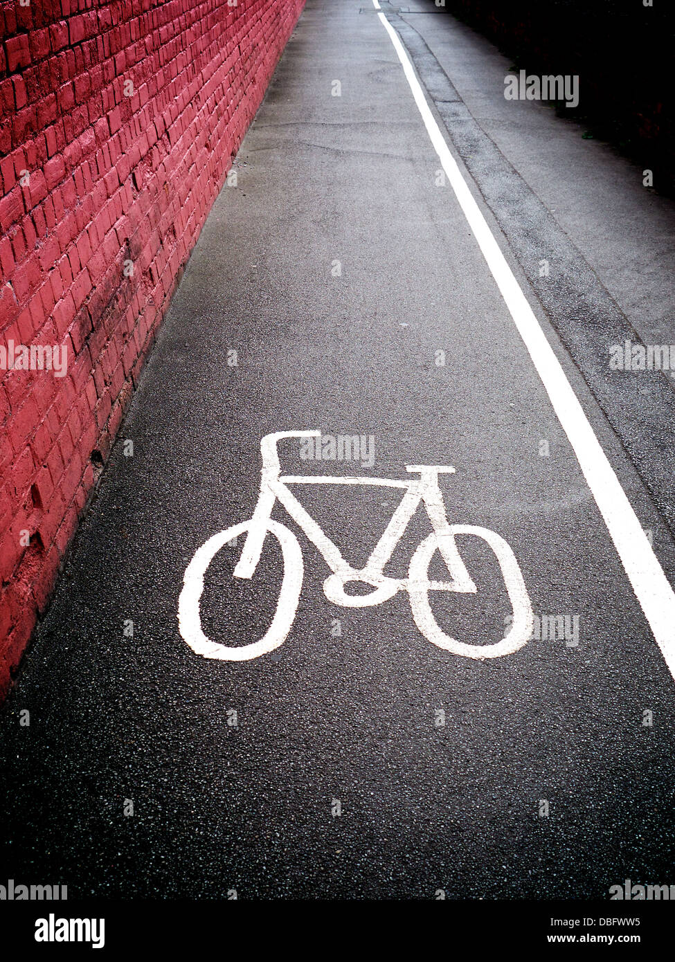 Fahren Sie Weg-Symbol auf einem britischen Gehweg Pflaster mit einer festen weißen Linie den Radweg von der Fussweg trennt. Stockfoto