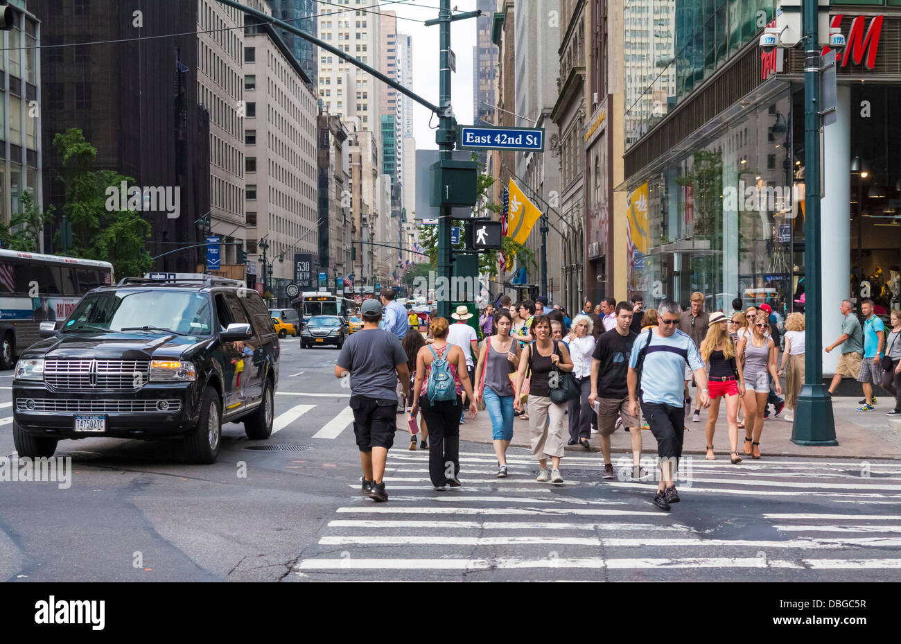 Manhattan Street Scene, New York - Menschen, die im Sommer über eine Kreuzung in der Innenstadt laufen Stockfoto
