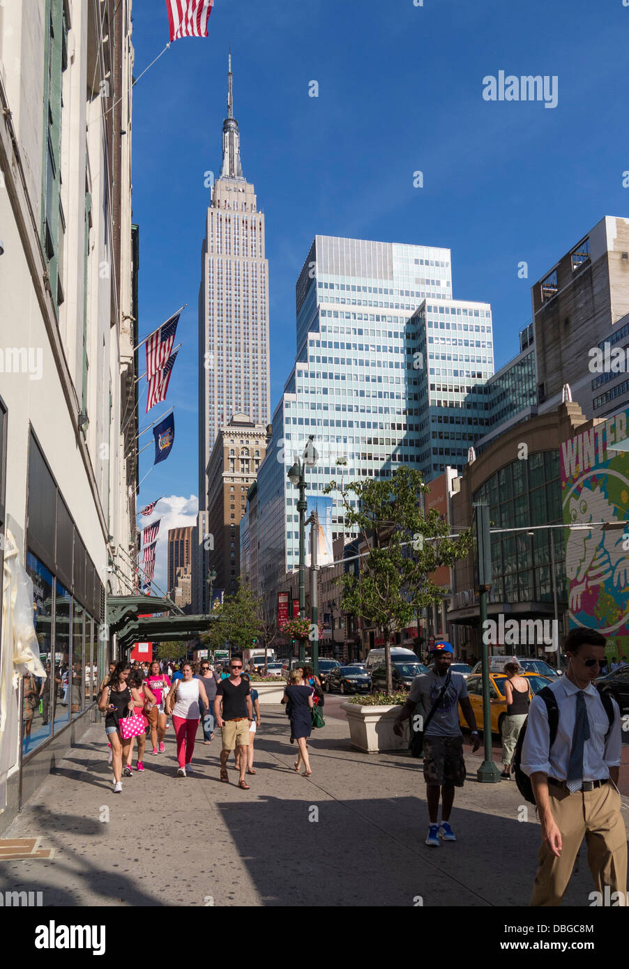 New Yorker Street - New Yorker auf dem Bürgersteig mit Empire State Building im Hintergrund, Manhattan, New York City im Sommer Stockfoto