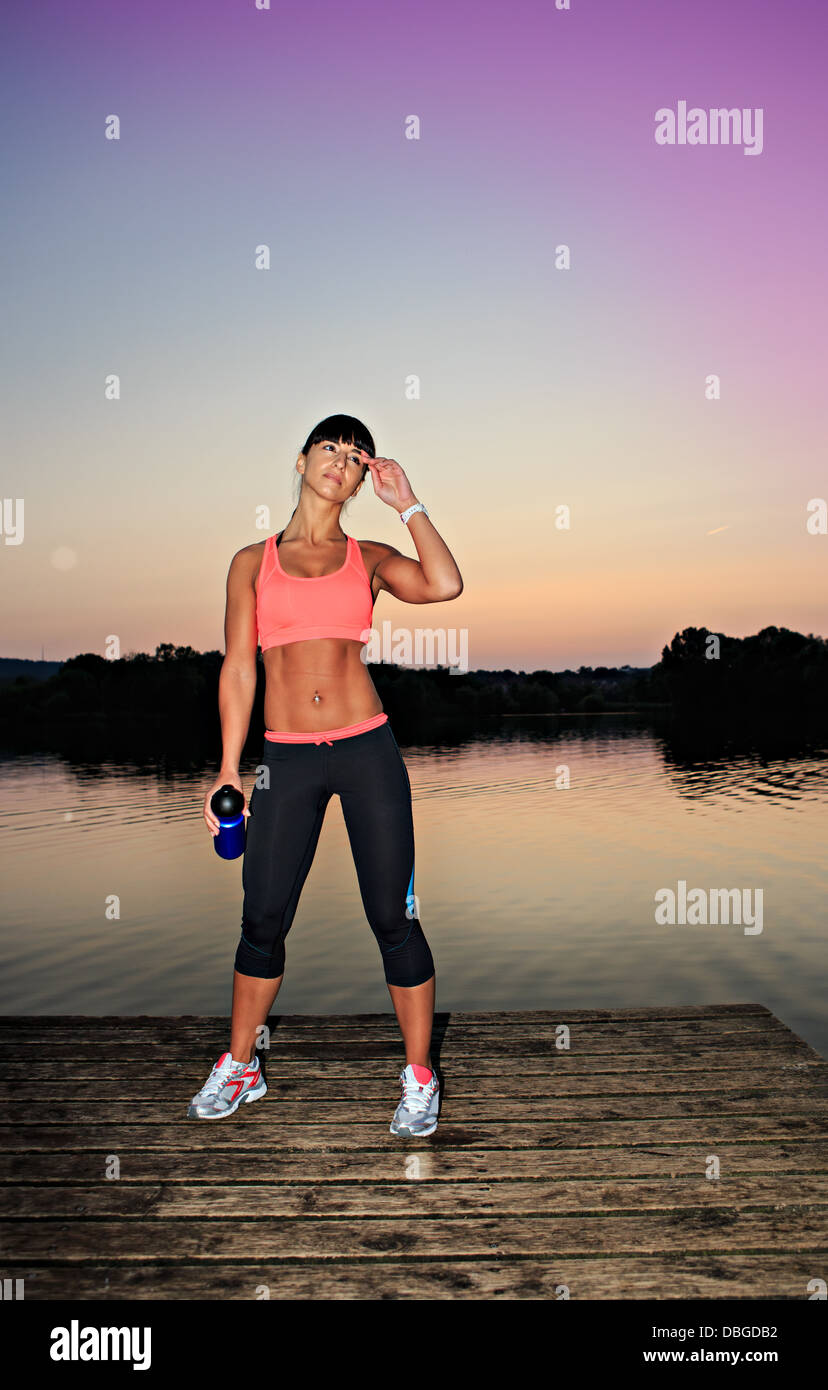 Frau machen Sie eine Pause vom Joggen vor einem See Stockfoto