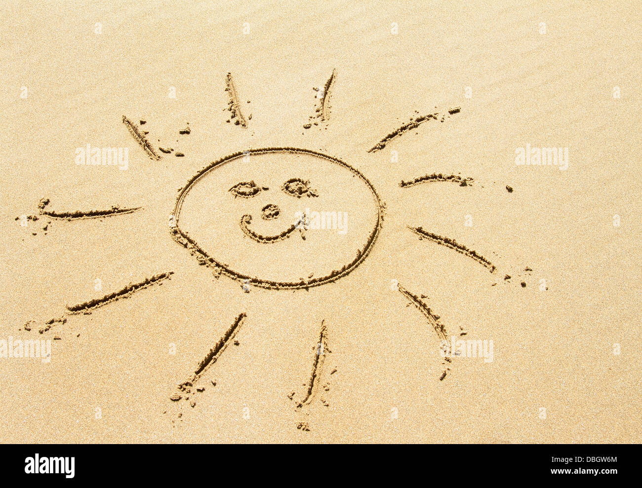 Sonnenzeichnung am goldenen Sandstrand Stockfoto