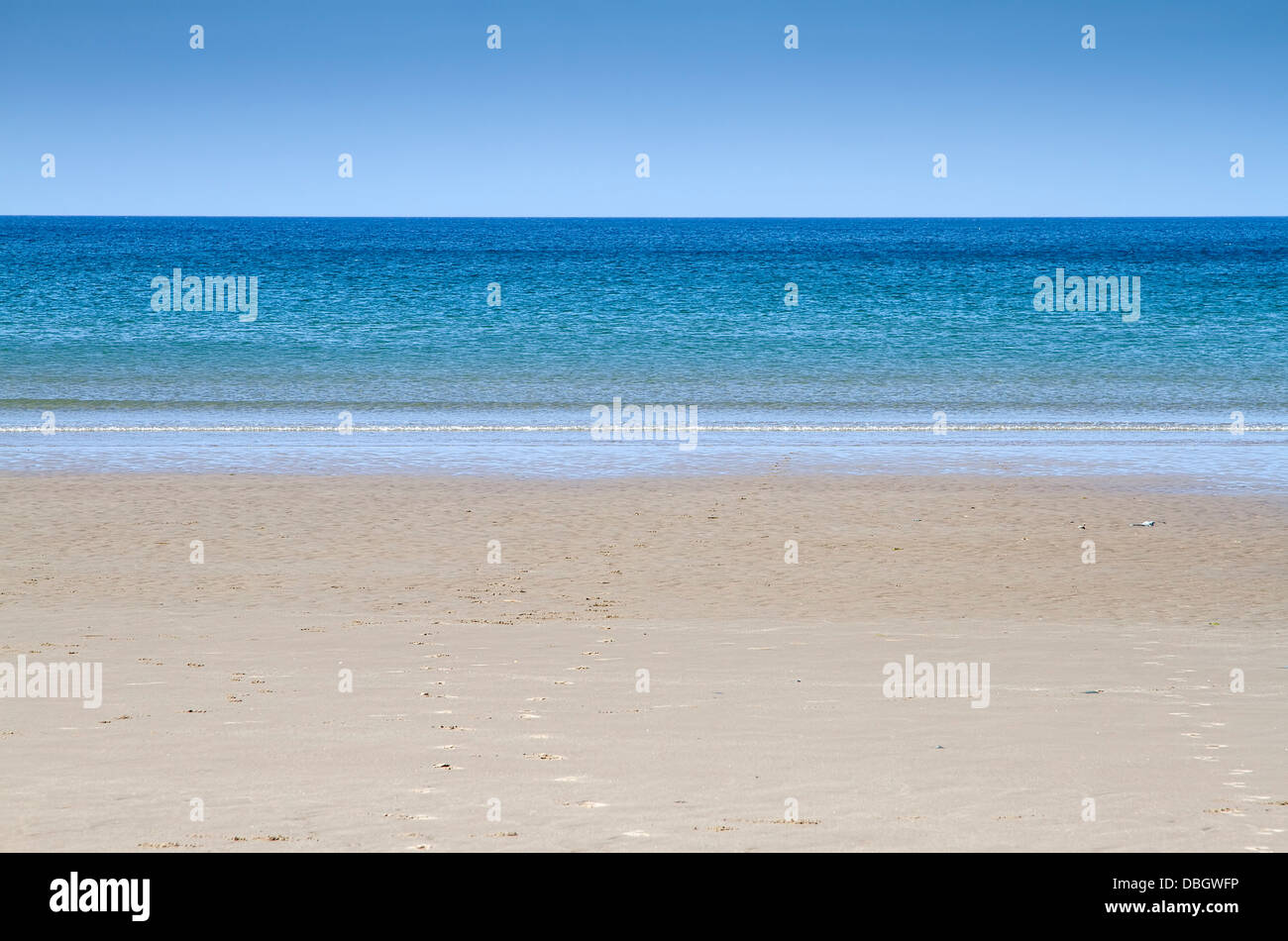 Leerer Strand mit blauem Himmel und Meer bei Barmouth, Wales UK Stockfoto