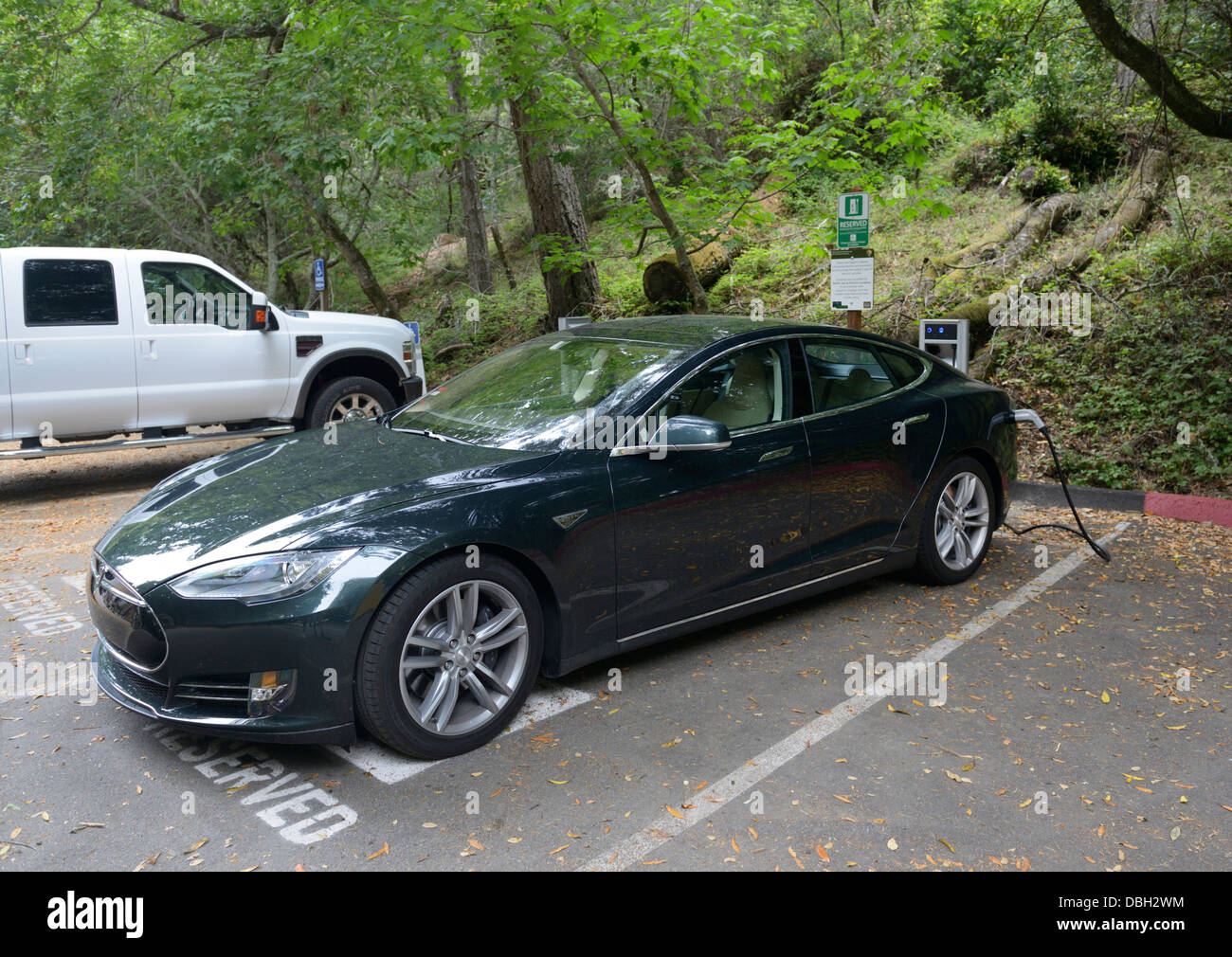 Ladestation mit einem Tesla Limousine Elektroauto eingesteckt.  Immobilienportal für details Stockfoto