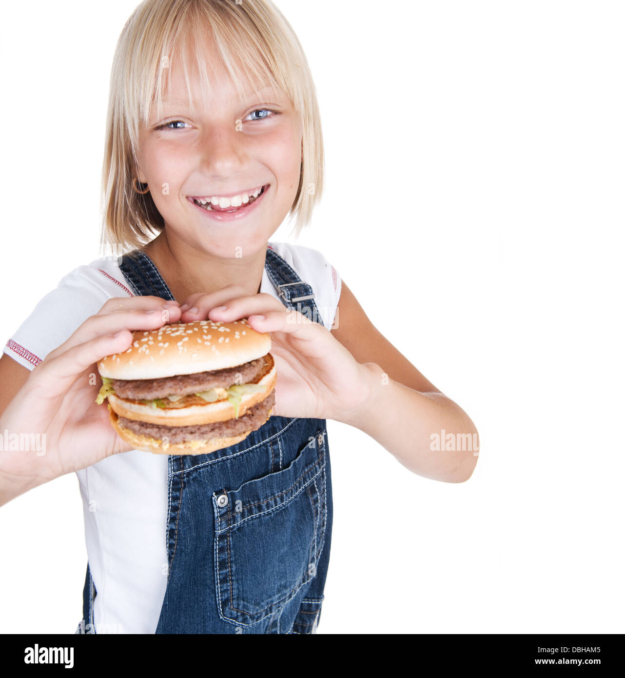 Glückliche kleine Mädchen essen Hamburger Stockfoto