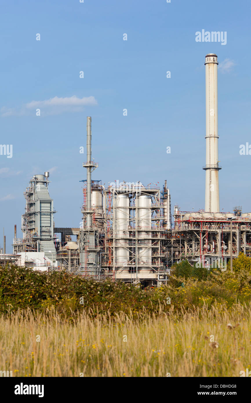Destillation-Türme und Rohre in einer Raffinerie tagsüber mit grünen Vordergrund. Stockfoto