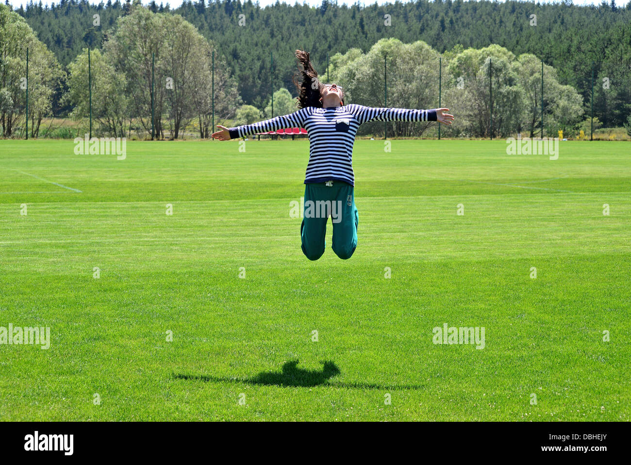 Mädchen auf dem grünen Rasen springen Stockfoto