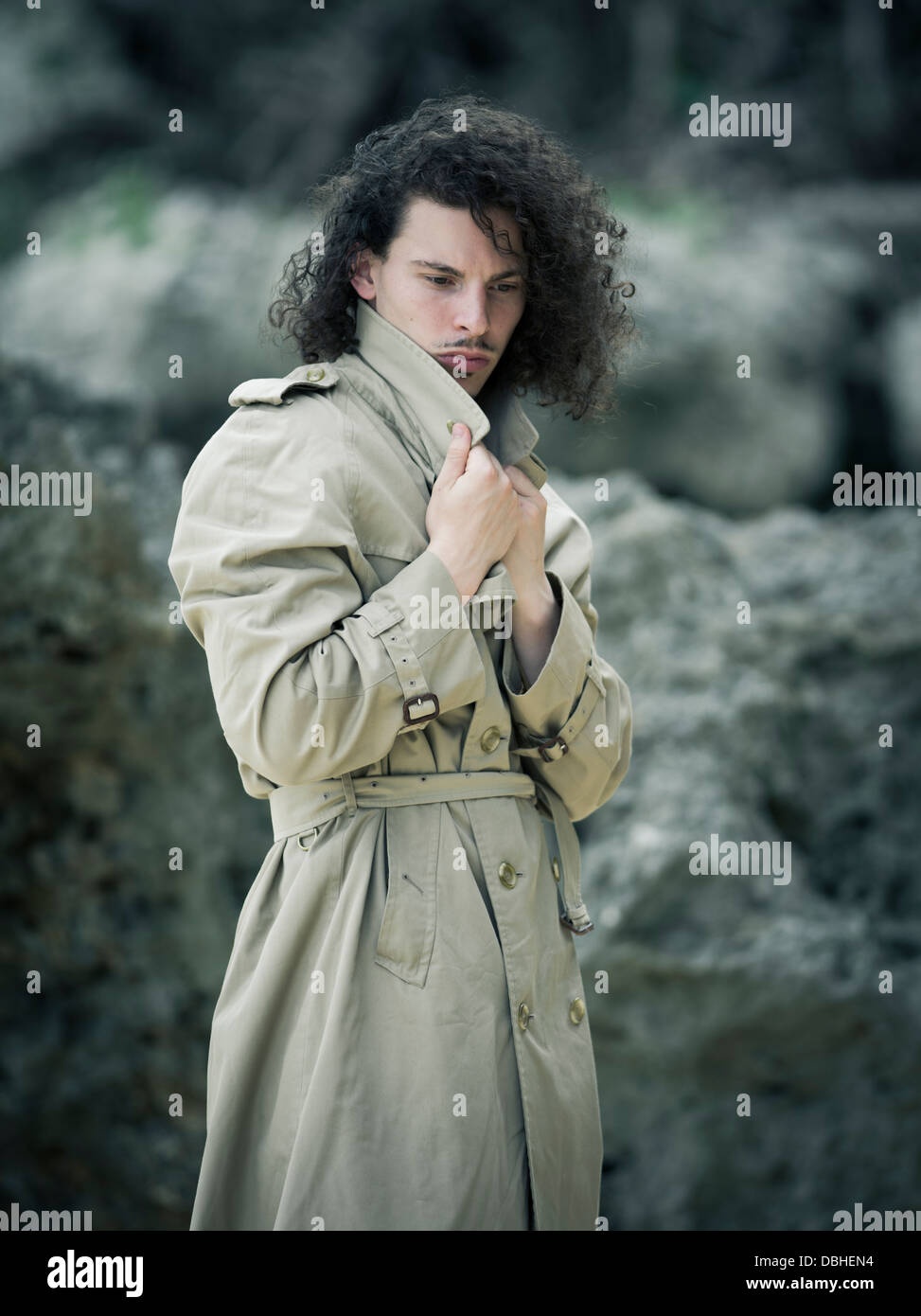 Mann mit langem lockigem Haar Bart und Schnurrbart tragen Burberry Trenchcoat Regenmantel Stockfoto