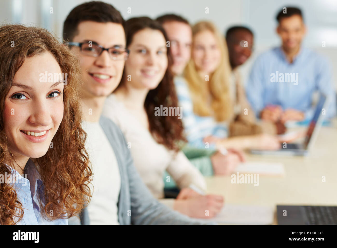 Glückliche Frau lernen Hochschule Seminar mit anderen Studenten Stockfoto
