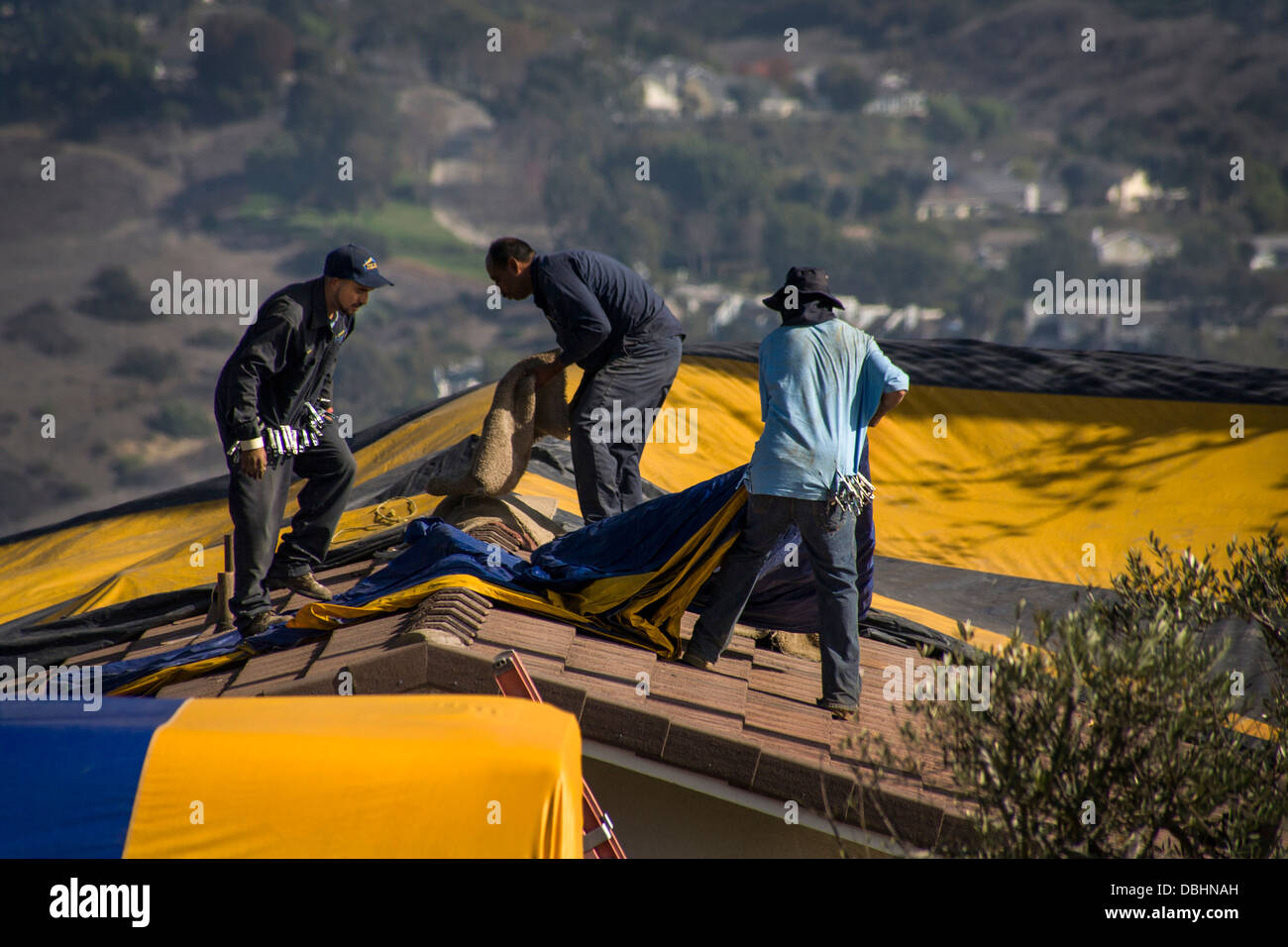Hispanische Arbeiter in Laguna Niguel, CA, decken ein Haus mit einem Gasproof Zelt vor Begasung Stockfoto