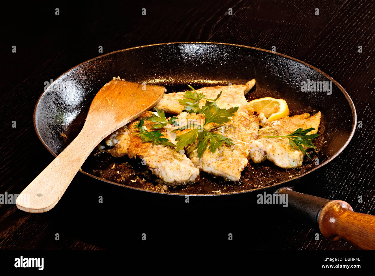 Gebratener Fisch in Pfanne mit Petersilie Stockfoto
