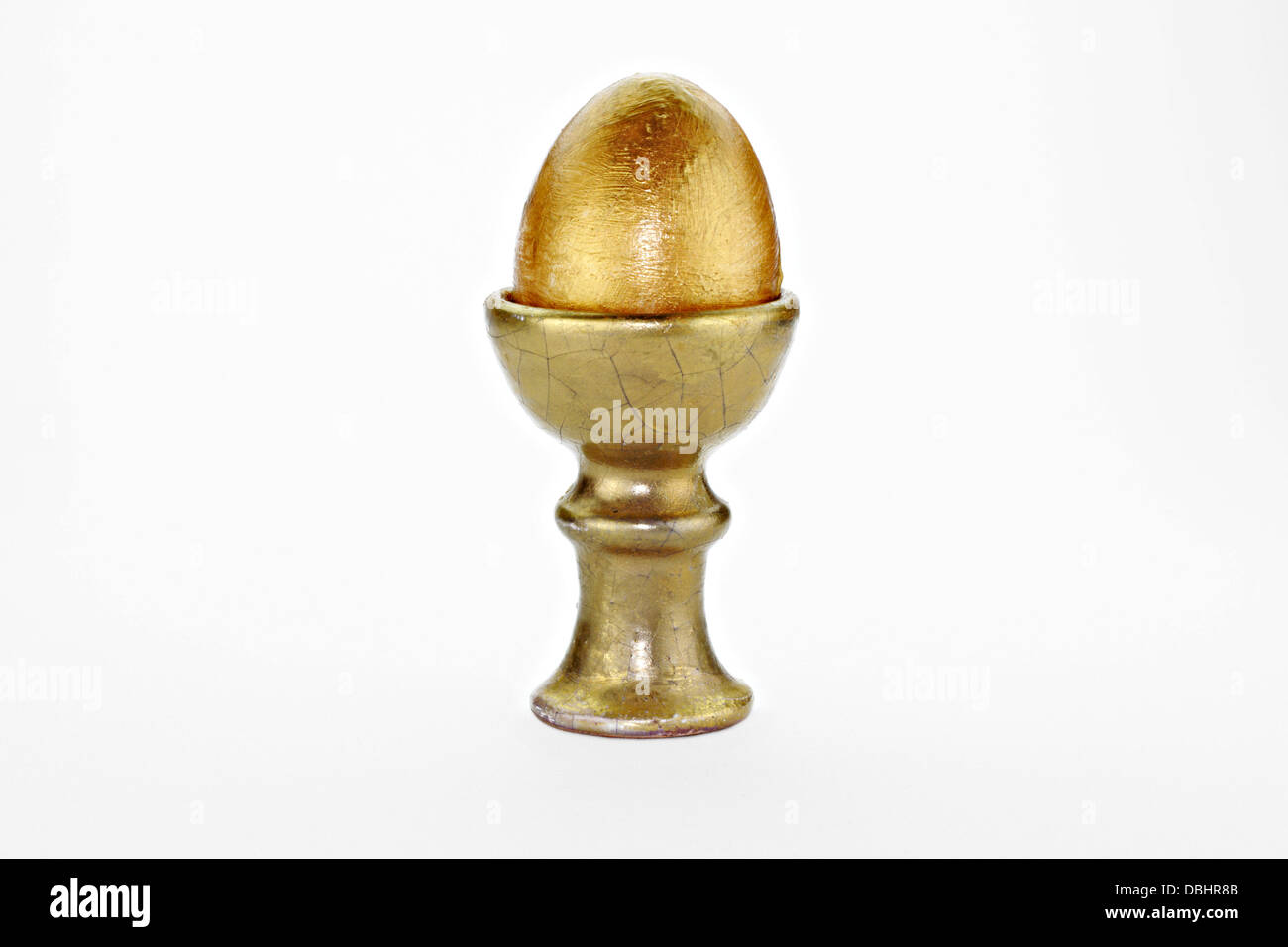 Hand bemalt gold-Ei in alten Eierbecher auf weißem Hintergrund Stockfoto