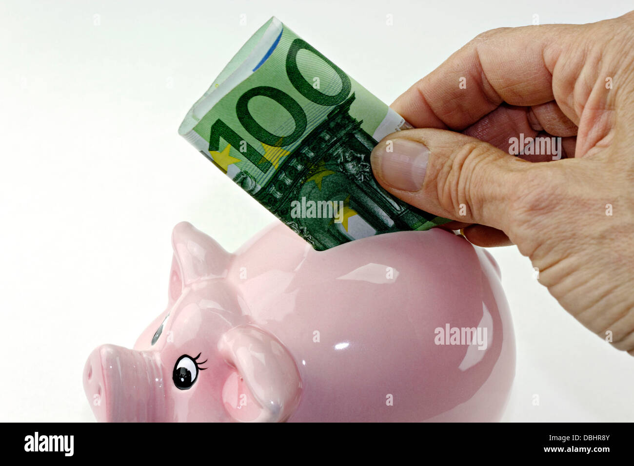 100 Euro-Banknote in eine rosa Sparschwein Spardose Stockfoto