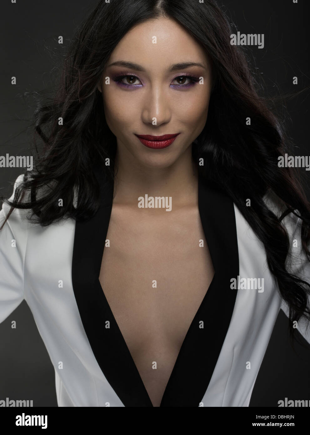 Schöne asiatische Frau in ihren Zwanzigern, mit schwarzen und weißen Jacke braless Stockfoto