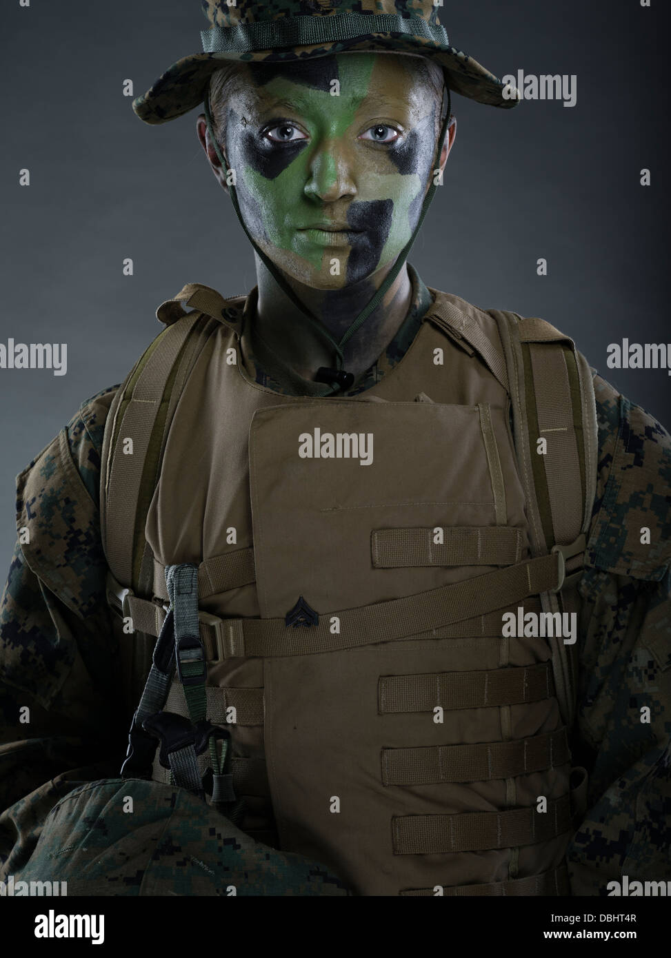 Porträt des United States Marine Corps Soldatin im Dienstprogramm uniform MARPAT pixelig Tarnung mit Camo Bemalung Stockfoto