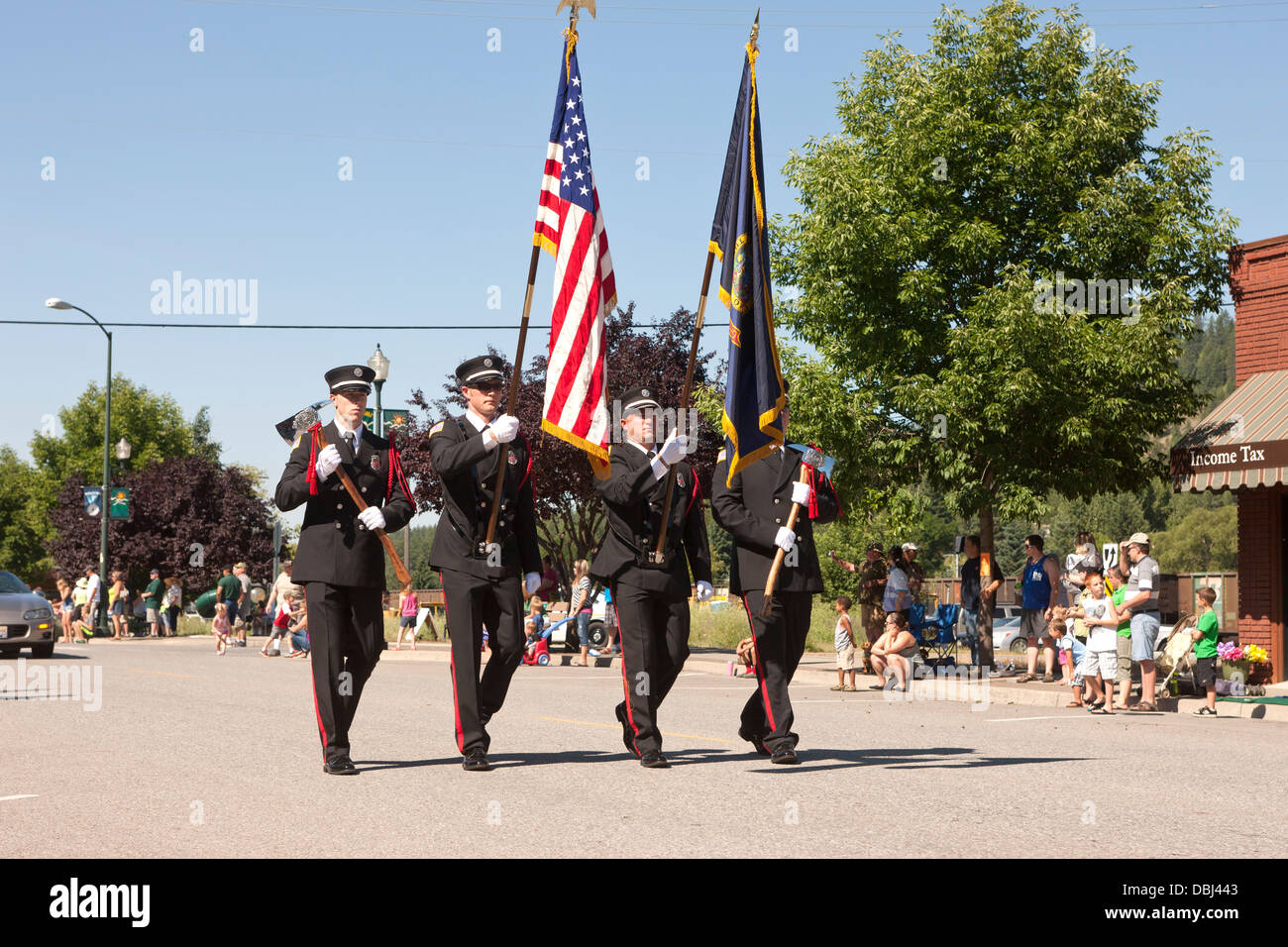 Feuerwehrleute tragen Fahnen Parade. Stockfoto