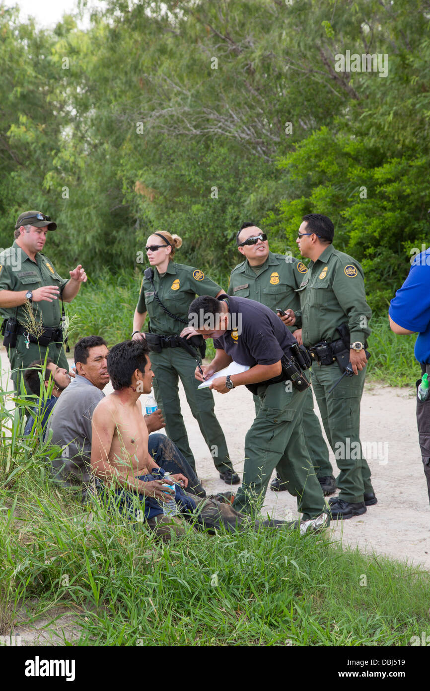 Border Patrol Agenten Frage Einwanderer aus Mittelamerika nach ein van mit 26 auf einem Texas Highway stürzte. Stockfoto