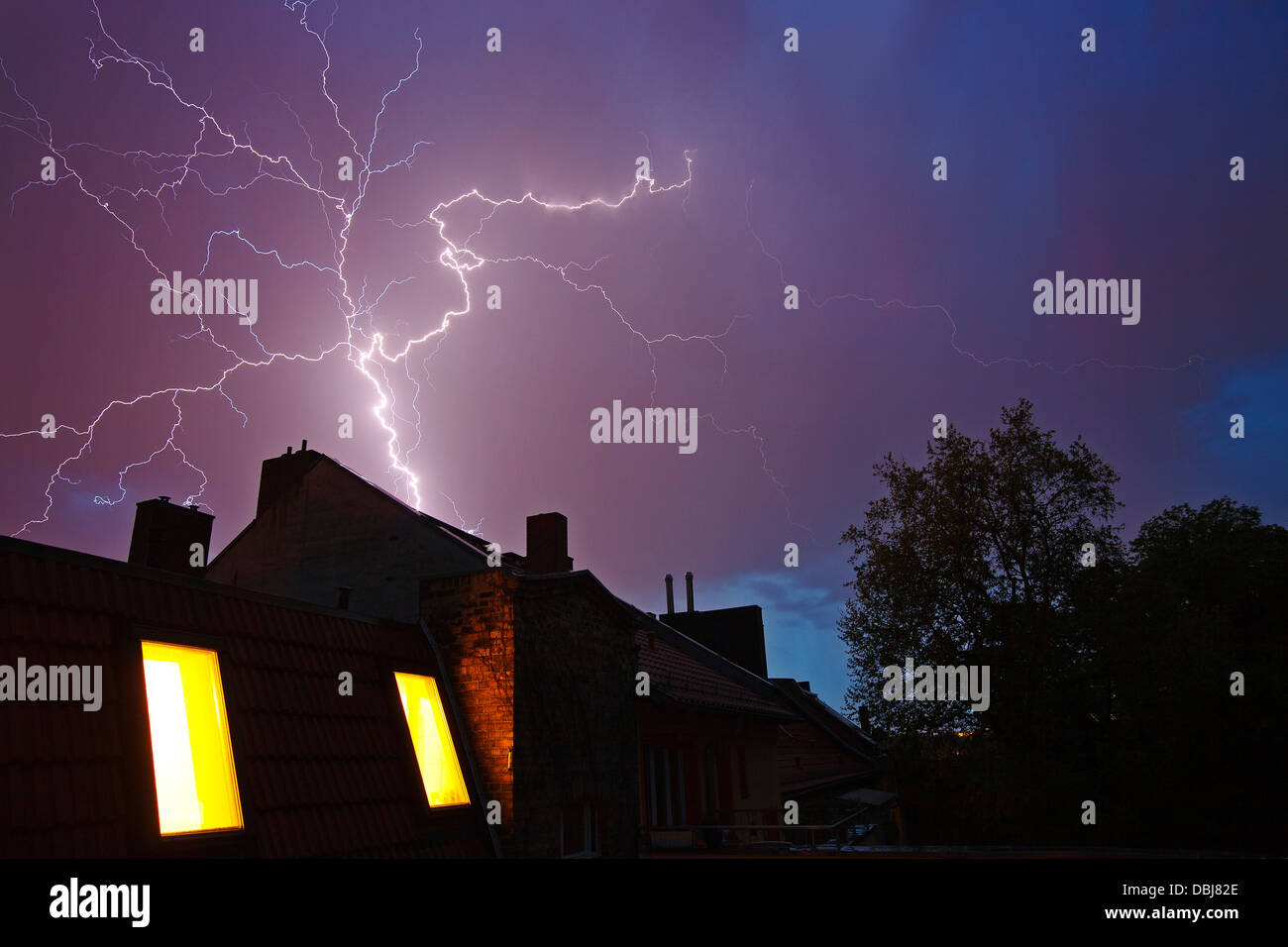 Gewitter mit Blitzen über den Dächern von Reihenhäusern Stockfoto