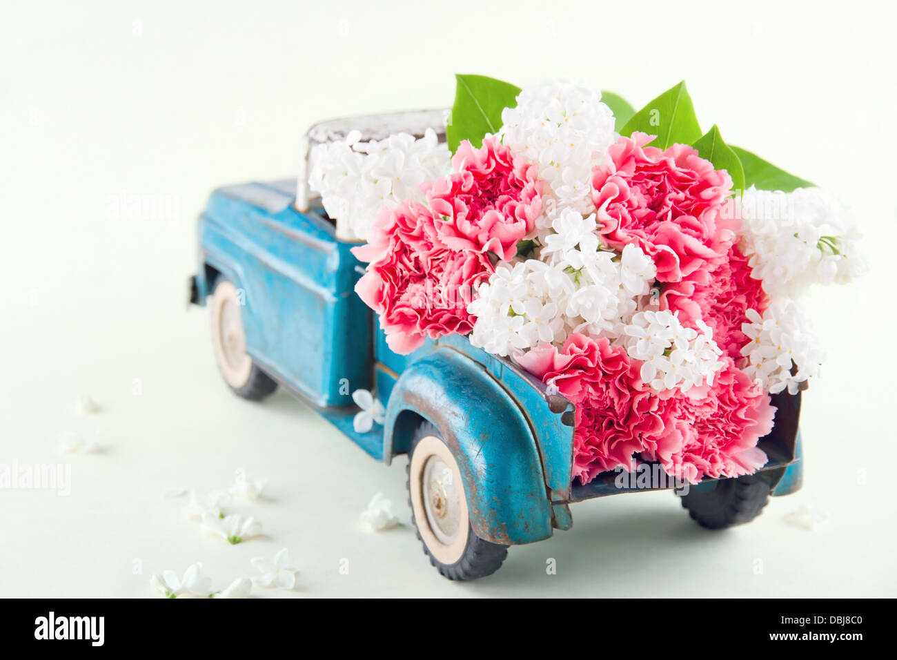 Alt antik Spielzeug-LKW tragen rosa Nelke und Flieder Blüten Stockfoto