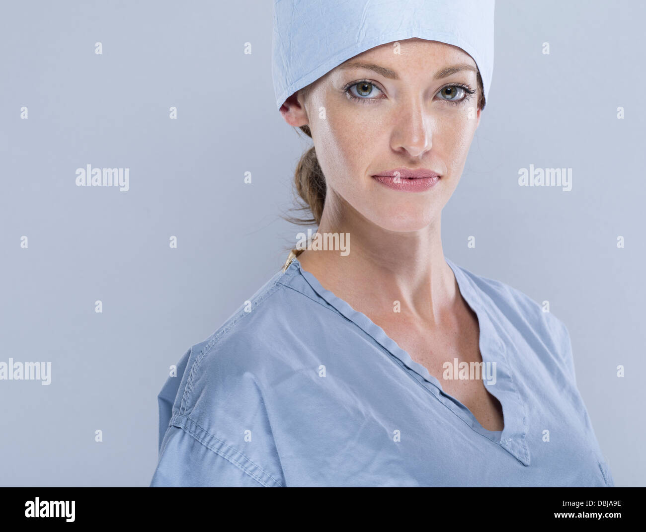 Weibliche Medic tragen scheuert sich chirurgische Kappe und Maske Stockfoto
