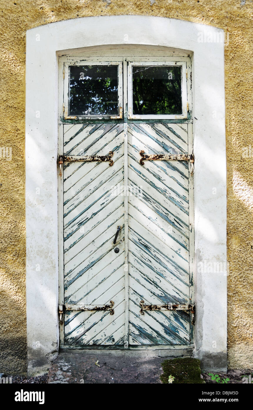alte weiße Holztür mit schmiedeeisernen Scharnieren Stockfoto